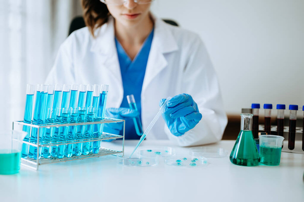 Female biotechnologist testing new chemical substances in a laboratory. - Zdjęcie, obraz