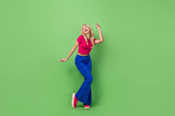 Full length photo of adorable charming lady dressed pink t-shirt dancing having fun isolated green color background. - Foto, immagini