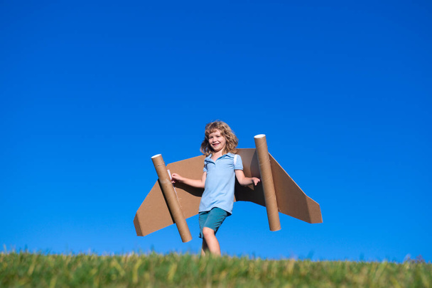 Šťastné dítě si hraje s hračkou jetpack. Dětský pilot se baví venku. Úspěšné dítě, inovace a vedoucí postavení. Tvůrčí a spouštěcí koncept - Fotografie, Obrázek