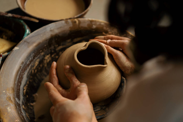 Pottery workshop a potter teaches student to sculpt jug from clay couple is engaged in pottery - Fotografie, Obrázek