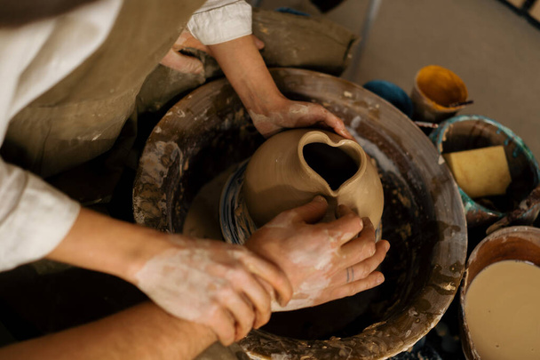 Atelier de poterie un potier enseigne à l'élève à sculpter cruche de couple d'argile est engagé dans la poterie - Photo, image