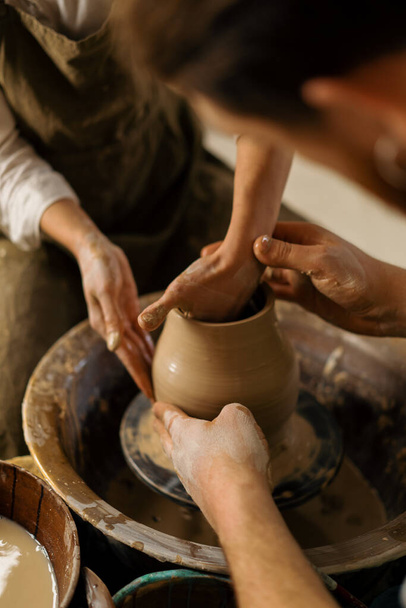 Pottery workshop a potter teaches student to sculpt jug from clay couple is engaged in pottery - Foto, Imagem
