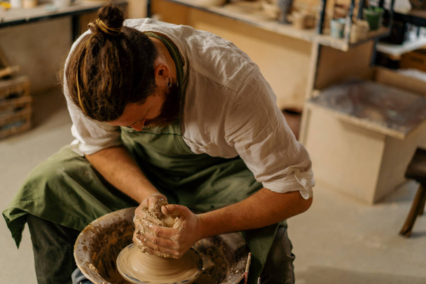 Atelier de poterie Un potier travaille avec de l'argile sur des outils de poterie de roue de potier - Photo, image