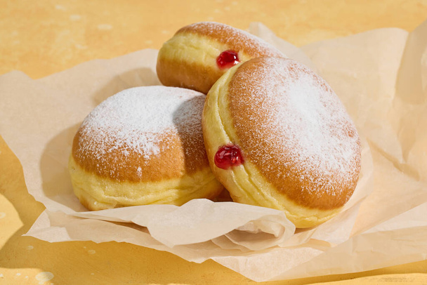 freshly baked jelly donuts on yellow background - Foto, afbeelding