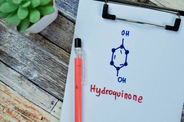 Concept of Hydroquinone write on paperwork, structural chemical formula isolated on Wooden Table. - Photo, Image