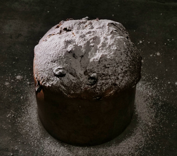 Süßes Brot mit Rosinen bestreut mit Puderzucker isoliert auf schwarz. - Foto, Bild