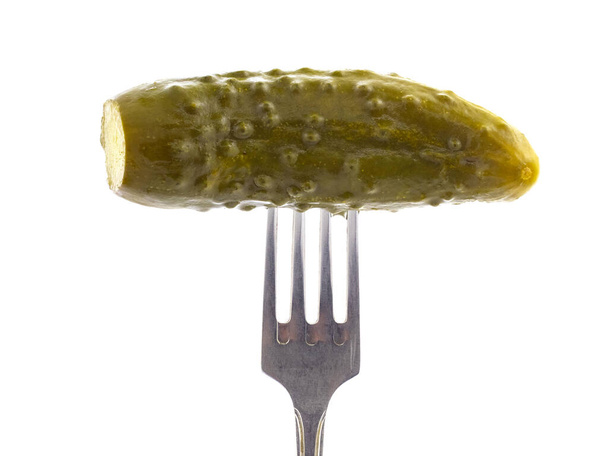 Pickled cucumber with a fork on a white background, isolated with shadow - Foto, immagini