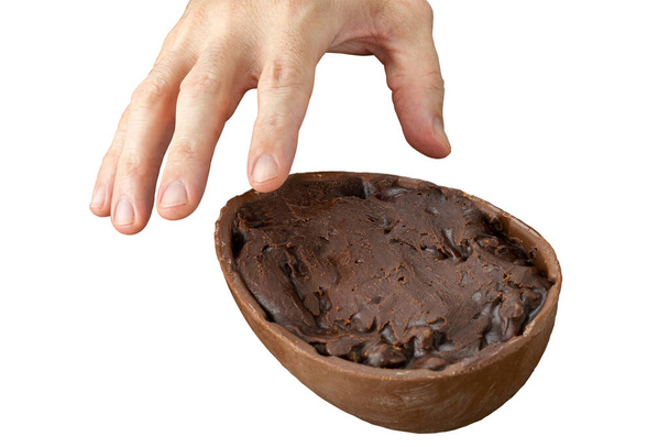 Mão do homem pegando ovo de Páscoa de chocolate cheio de nozes e chocolate escuro. - Foto, Imagem
