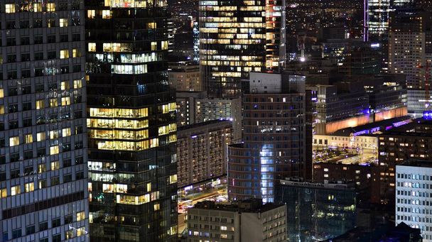 Вид на ночные стеклянные здания и современные бизнес-небоскребы. Вид на современные небоскребы и деловые здания в центре города. Большой город ночью. - Фото, изображение
