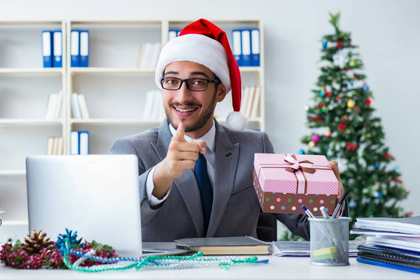 Ο νεαρός επιχειρηματίας γιορτάζει τα Χριστούγεννα στο γραφείο - Φωτογραφία, εικόνα