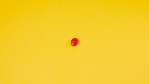 Pillola rossa su sfondo giallo. Concetto minimo. Vista dall'alto. - Foto, immagini