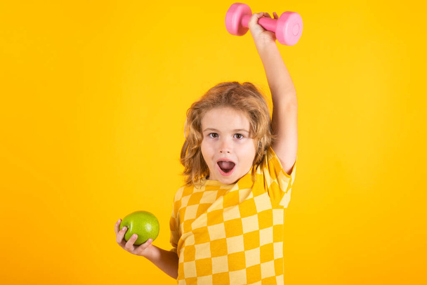 Sport activities at leisure with children. Sporty kid boy holding dumbbells - Zdjęcie, obraz