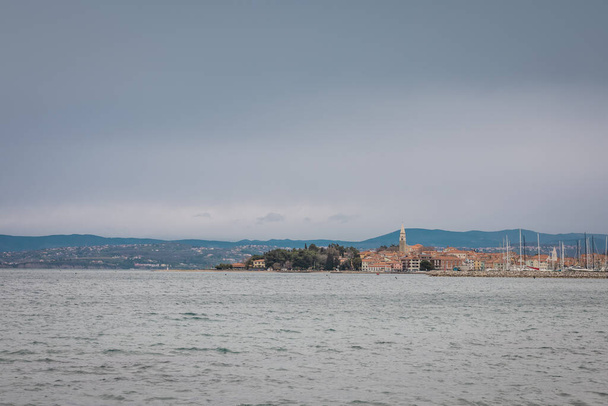 Hideg tél vagy kora tavaszi panoráma Izola város északi részén Adriai-tenger. Marina az előtérben. - Fotó, kép