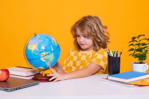Back to school. Funny little boy from elementary school looking at globe during geography lesson. Education - Photo, Image