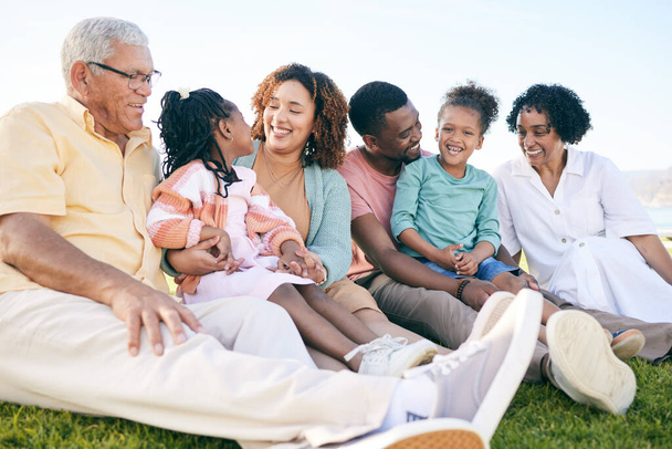 Family, smile and generations outdoor, happy people relax on lawn with grandparents, parents and kids. Happiness, unity and sitting together on grass, diversity and love with relationship and bond. - 写真・画像