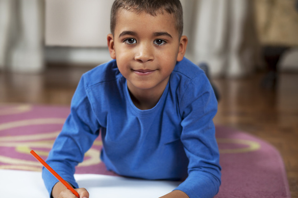 Jeune garçon métis dessin sur papier avec crayon
. - Photo, image