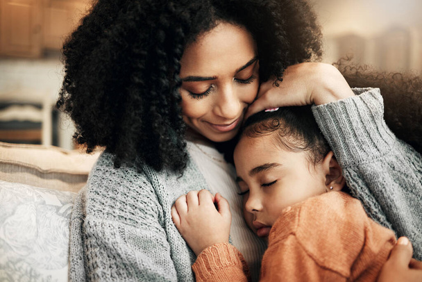 Family, love or child hug mother for Mothers Day, home bonding or embrace on living room couch. Care, custody and biracial mom, mama or woman with female youth kid, girl or daughter cuddle on sofa. - Фото, изображение