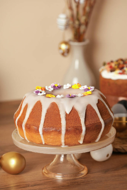 Delicious Easter cake decorated with sprinkles near painted eggs on wooden table - Φωτογραφία, εικόνα