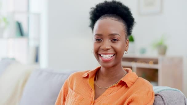 Black woman, face and smile on sofa in home living room with comic laugh, relax or peace in morning, Girl, lounge couch and happiness in portrait in house for me time, freedom or sitting in apartment. - Footage, Video