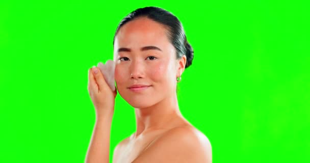 Face smile, skincare and Asian woman with stone on green screen in studio isolated on a background. Dermatology, cosmetics portrait and happy female model with rose quartz gua sha for skin massage - Materiał filmowy, wideo