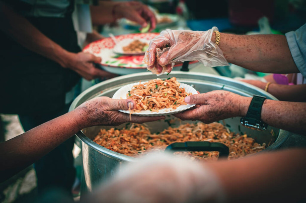 volunteer serving food to the homeless in the Community Charitable Donation Center Concept of free food assistance service - Foto, Imagen