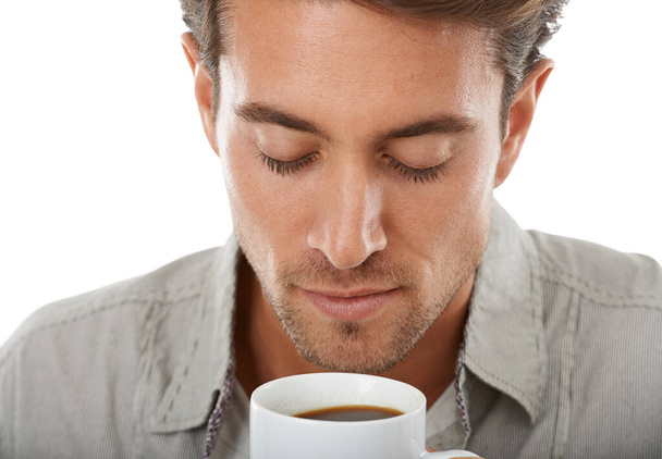 The smell of fresh coffee. A handsome young man enjoying the aroma of a fresh cup of coffee - 写真・画像