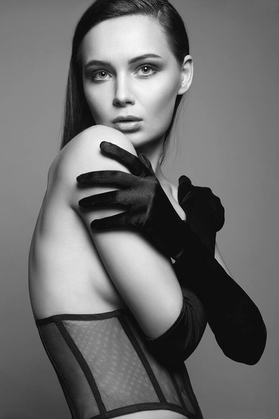 Μελαχρινή με γάντια και εσώρουχα. Μαύρο και άσπρο πορτρέτο της σέξι Όμορφη νεαρή γυναίκα - Φωτογραφία, εικόνα