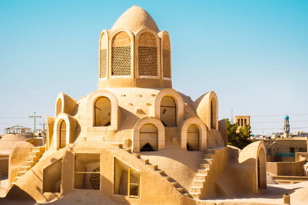 Historic castle in Kashan with city buildings background. Explore iran historical heritage concept - 写真・画像