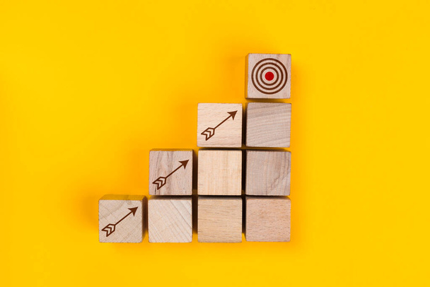 Business strategy, economic growth, meeting targets concept with arrow icons on wooden cubes - Fotoğraf, Görsel