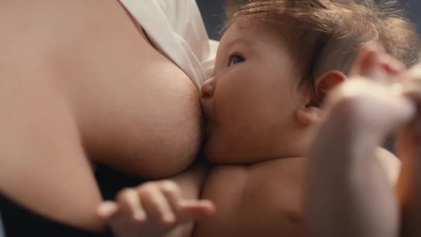 Close-up van Aziatische baby borstvoeding van moeder en spelen met zijn benen. Opgenomen met RED helium camera in 8K.   - Video