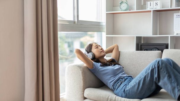 Woman happily listening to music on her favorite sofa in the living room, Relaxation time, Happy time, Feel good, Happy women resting at work after work is finished, Chill, Fatigue is eased. - Photo, Image