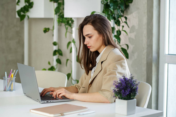 A nő laptopon dolgozik a modern irodában. Számviteli elemzési jelentés készítése ingatlanbefektetési adatok, pénzügyi és adórendszer koncepció - Fotó, kép