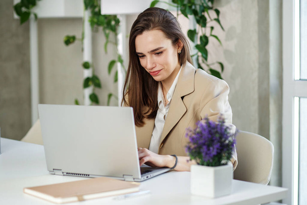 De vrouw werkt op een laptop computer in een modern kantoor. Boekhoudkundig analyseverslag vastgoedbeleggingsgegevens, financieel en fiscaal systeemconcept - Foto, afbeelding