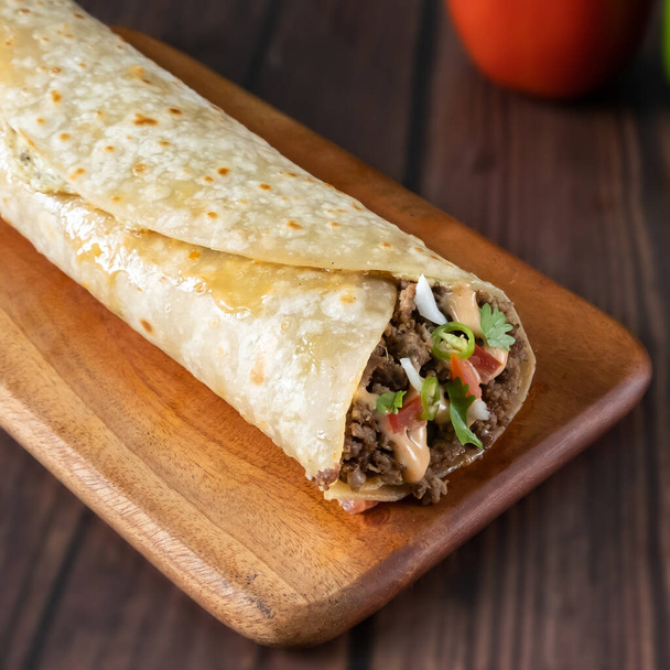 Arab Minced Beef Wrap paratha roll served in wooden board side view of indian fastfood - Photo, Image