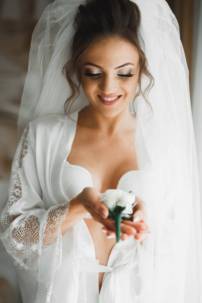 Beautiful luxury bride in elegant white dress holds bouquet of flowers in the hands. - Foto, Imagem