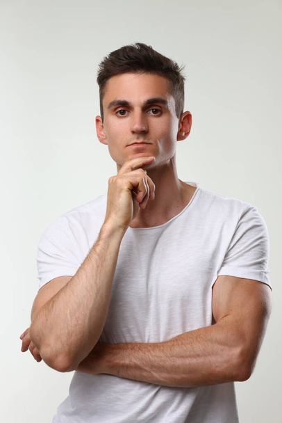 Portrait of young handsome athletic man in white t-shirt. Male brutality and masculinity concept - Photo, Image