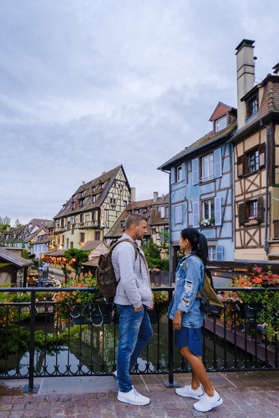 Colmar, Alsace, France. Petite Venice, men, and women visit the traditional half timbered houses. Colmar charming town in Alsace, France. Beautiful view of colorful romantic city Colmar  - 写真・画像