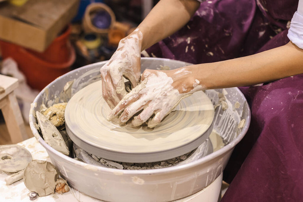 Pottery workshop. Female ceramic artist molding clay pottery wheel. Creative handmade craft.  - Foto, afbeelding