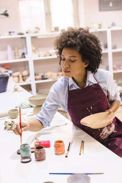 Ritratto di donna afro americana, ceramista, laboratorio, ciotola di argilla. Artigianato creativo. Studio di ceramica. - Foto, immagini