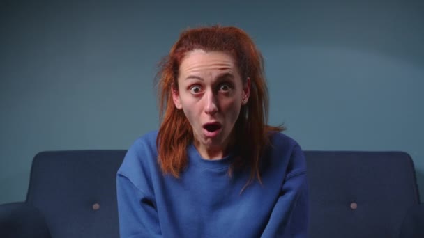 Shocked woman face with opened mouth and big eyes looking to camera on blue background. Portrait amazed girl and opened mouth in surprise. Facial people emotion. High quality 4k footage - Footage, Video