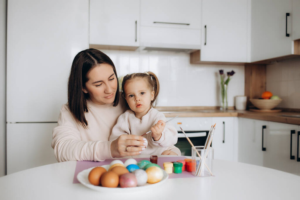 mother and daughter are preparing for Easter, hugging, smiling, spending, enjoying time together, wearing bunny ears, - Valokuva, kuva
