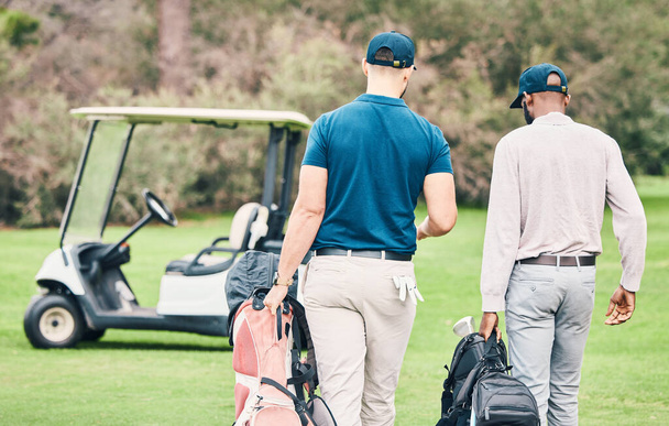 Golf, deportes y hombres en curso con bolsa de golf caminando al carro después del juego, la práctica y el entrenamiento en el césped. Golfistas profesionales, diversión y espalda de amigos en la hierba para el ejercicio, fitness y competición. - Foto, Imagen