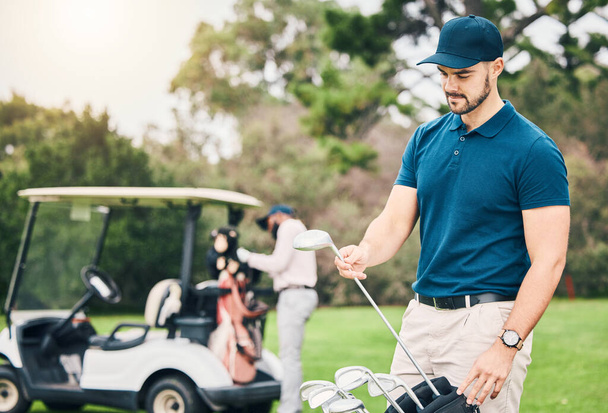 Golf, sport i człowiek na polu golfowym z torbą klubów gotowy do rozpoczęcia gry, praktyki i szkolenia na trawniku. Profesjonalny golfista, aktywność i męski caddy na trawie do ćwiczeń, fitness i rekreacji. - Zdjęcie, obraz