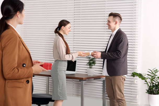 Man presenting gift to his colleague in office - Foto, imagen