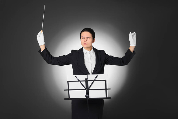 Professional conductor with baton and note stand on grey background - Фото, зображення