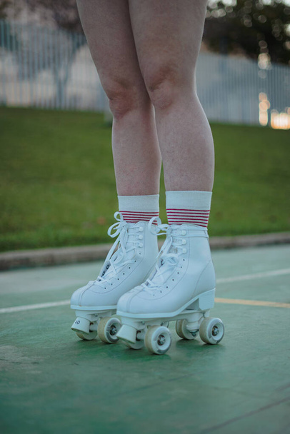 脚の十代の女の子の白いローラースケートを身に着けている. - 写真・画像