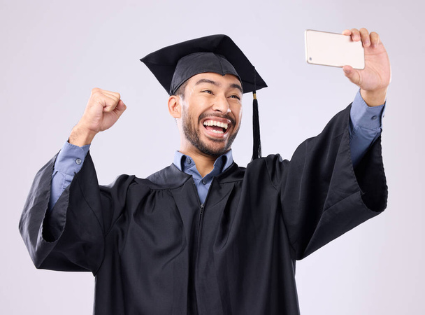 Homme, diplômé et selfie avec le sourire pour l'érudition, photo de profil ou les médias sociaux sur fond de studio gris. Heureux sourire académique masculin excité pour la photo de graduation, mémoire ou poste en ligne. - Photo, image