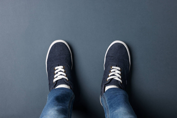 Child in stylish sneakers standing on grey background, top view - Photo, Image