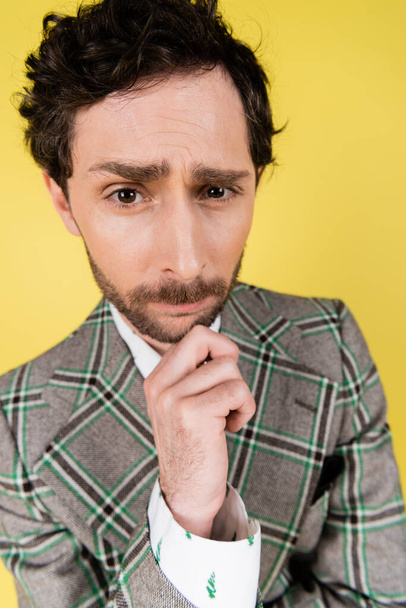 Wide angle view of focused and stylish man looking at camera isolated on yellow   - Photo, image