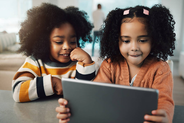 Siostry, dzieci i dziewczęta uśmiechają się z tabletem w domu, grając w gry i łącząc się. Technologia, rodzina i szczęśliwy mieszany wyścig dzieci z ekranem dotykowym do elearning, streaming filmu lub przeglądania stron internetowych. - Zdjęcie, obraz
